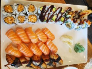 Taiyou Japanese Shabu & Sushi - tempura maki (top left), eel avocado maki (middle left), hokkaiyaki maki (bottom left), salmon nigiri (center), eel nigiri (right)